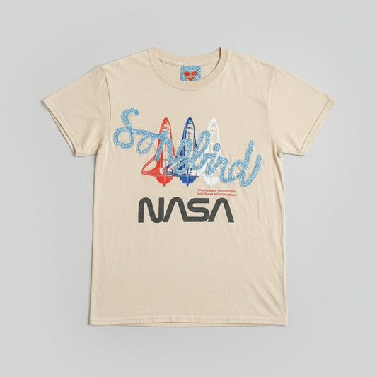 Beige t-shirt with 'Soyuz' and NASA logo on a wooden surface