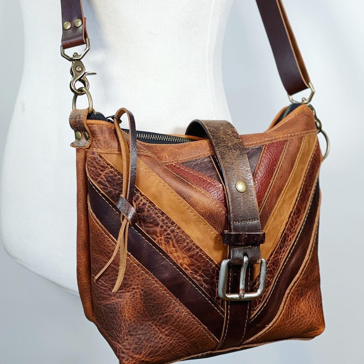 Brown leather handbag with a zigzag pattern on a white background